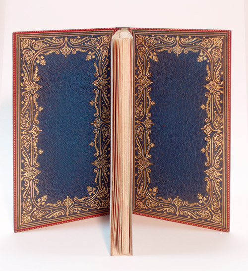 Lowell's "Democracy"; Inner Doublures of Bright Blue, with Scarlet Dentelles (turn ins).  Wide border comprising the same and similar Floral tools from the Front Boards, with triple gilt rule at Doublures' perimeter, and dotted rule at thin Dentelle Edges. Pale Light Blue Watered Silk Endpapers